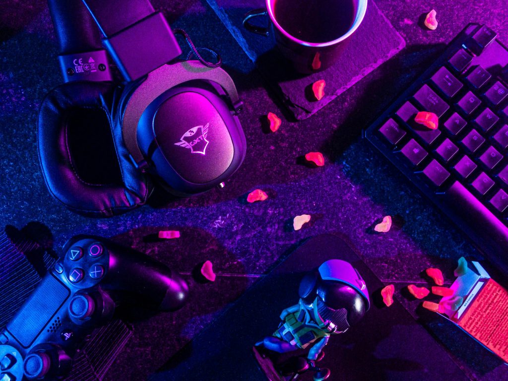 pexels photo 3165335 3165335 Colorful flat lay of gaming gear including headset, controller, and keyboard under vibrant lighting.